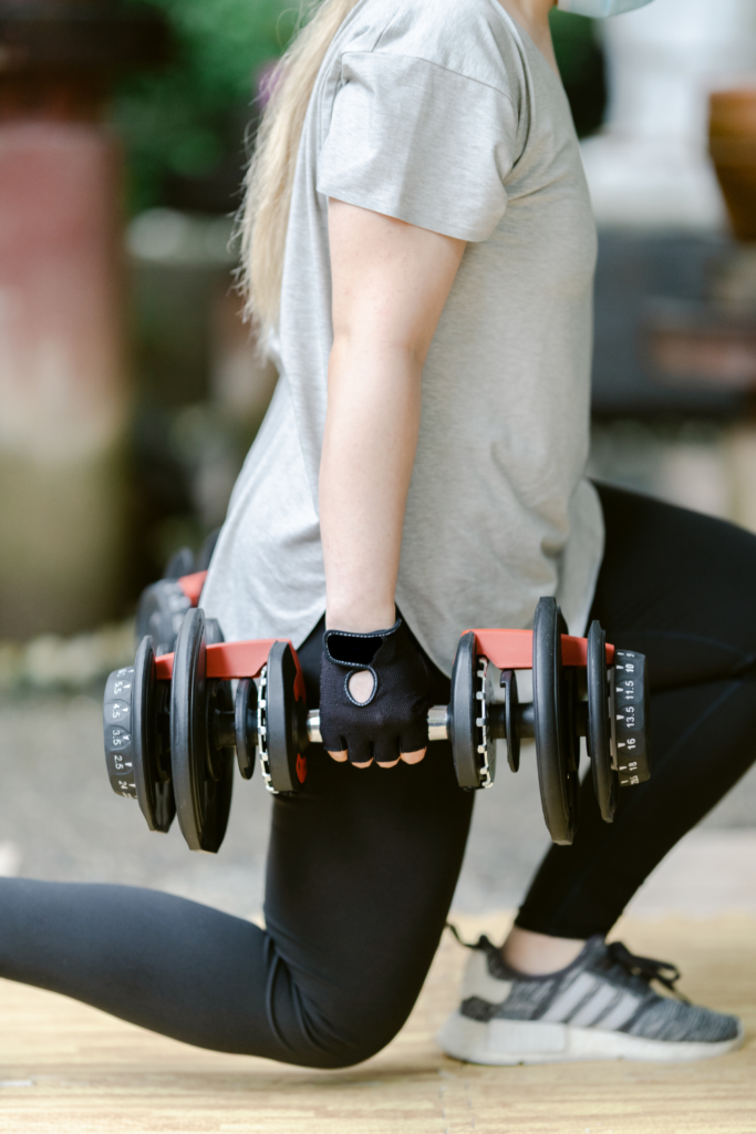 muscle mommy working out with adjustable dumbbells