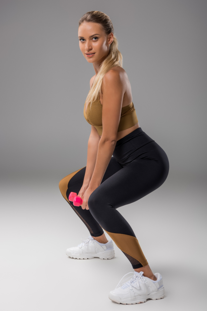 woman doing a squat with a dumbbell