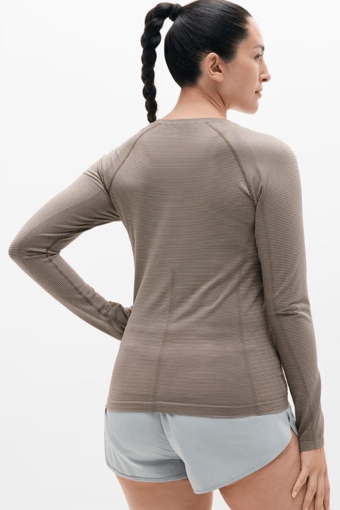 Woman wearing a moisture-wicking long sleeve  winter workout outfit top