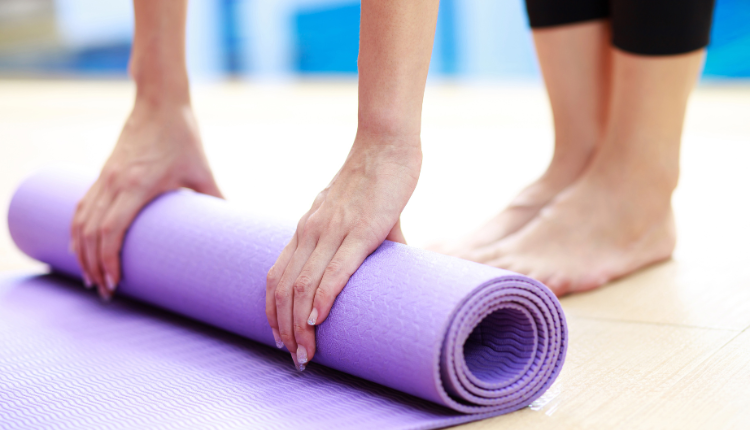 woman rolling a yoga mat