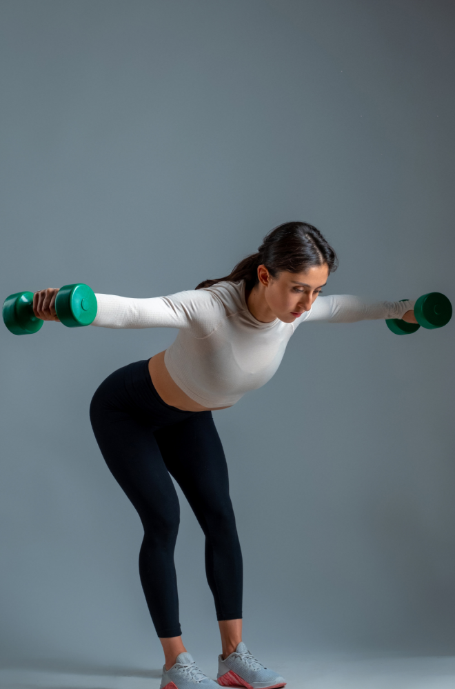 woman performing a dumbbell exercise at home